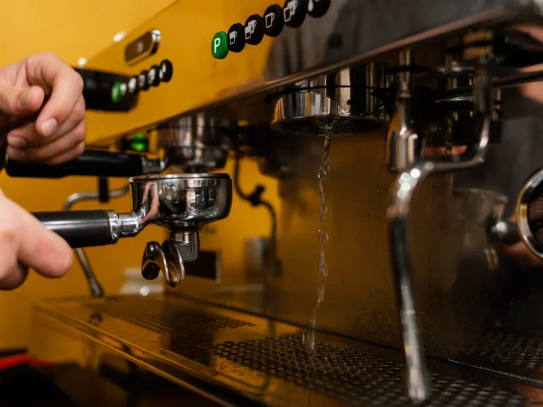 Barista vận hành máy pha cà phê chuyên nghiệp tại quầy