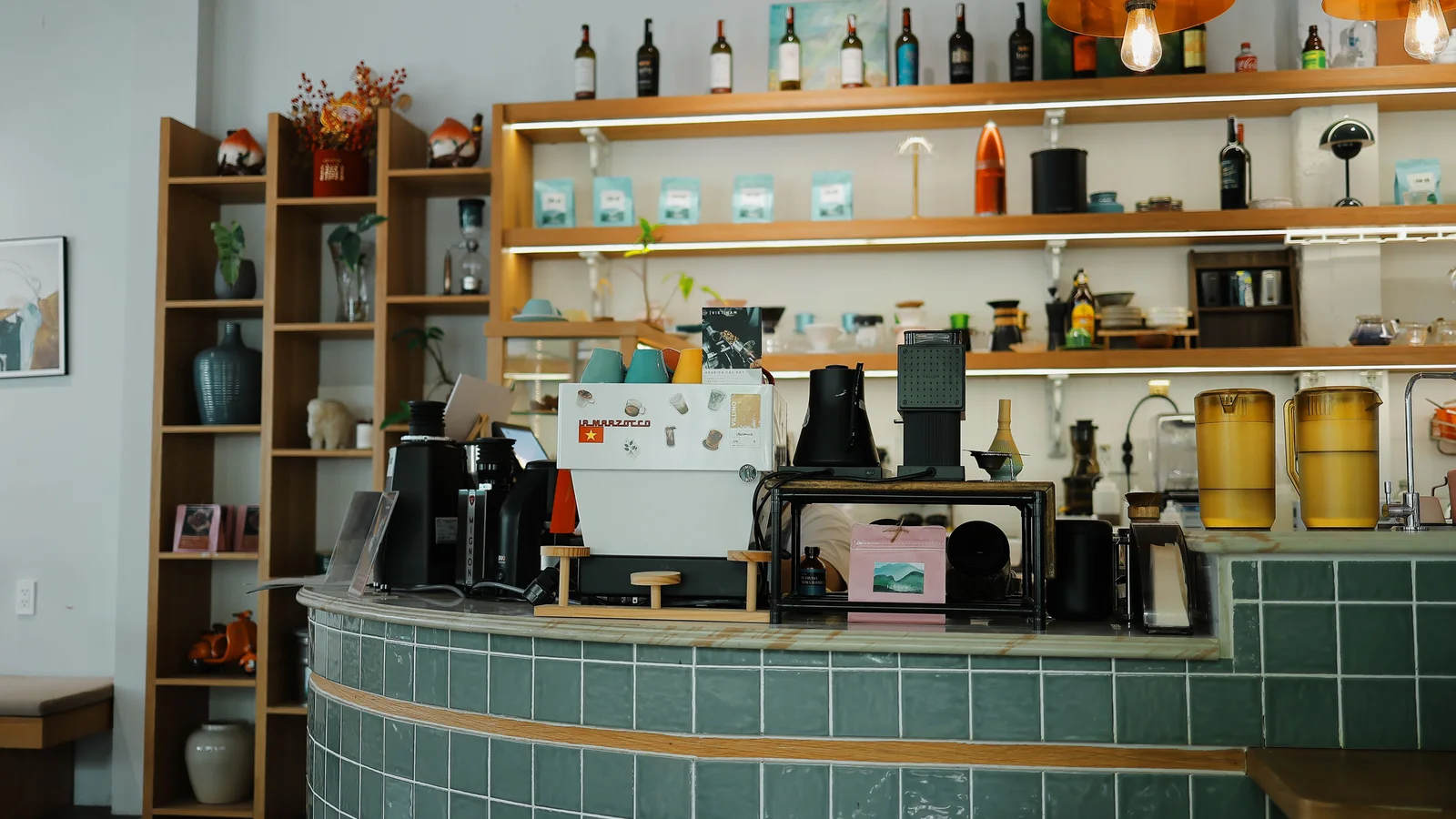 Quầy bar cà phê chuyên nghiệp với máy pha espresso, máy xay và quầy ốp gạch xanh — ảnh minh họa
